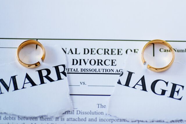 Divorce decree and two broken wedding rings. Divorce and separation