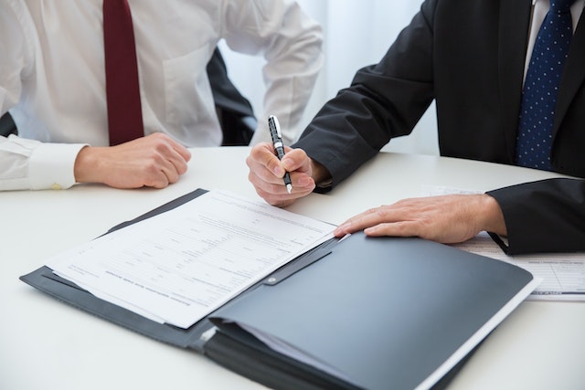 two people looking at documents and writing