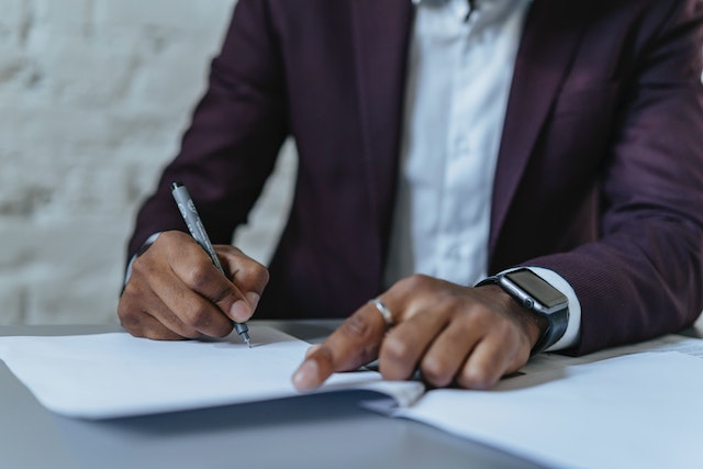 man signing document