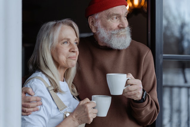 older adults holding coffee mugs